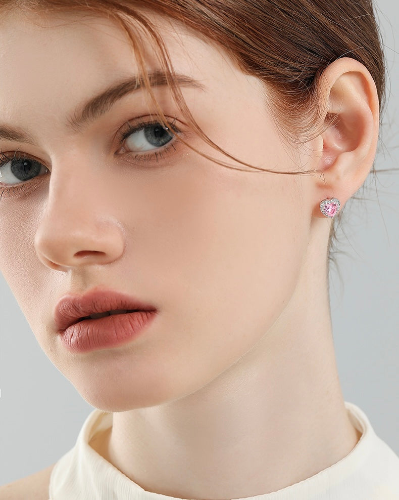 Close-up of a woman wearing pink earrings with a gray background
