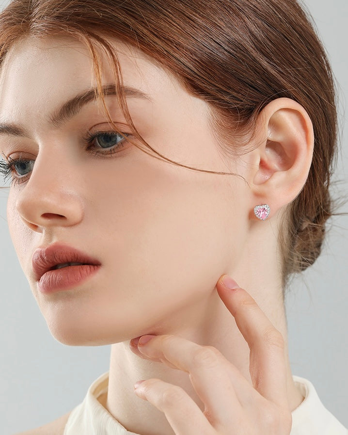 Close-up of a woman wearing pink earrings with a neutral background