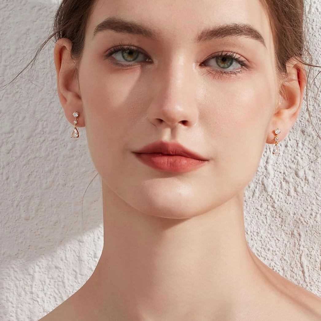 Close-up of a woman wearing earrings against a neutral background
