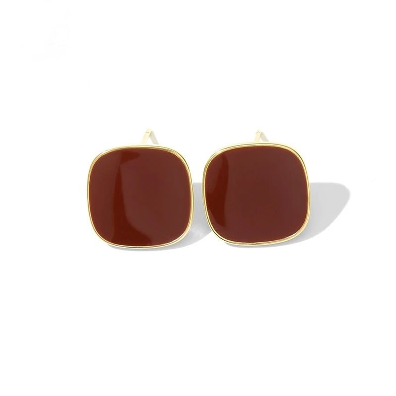 Close-up detail of Bordeaux Enamel Earrings showing red enamel finish and gold accents on white background