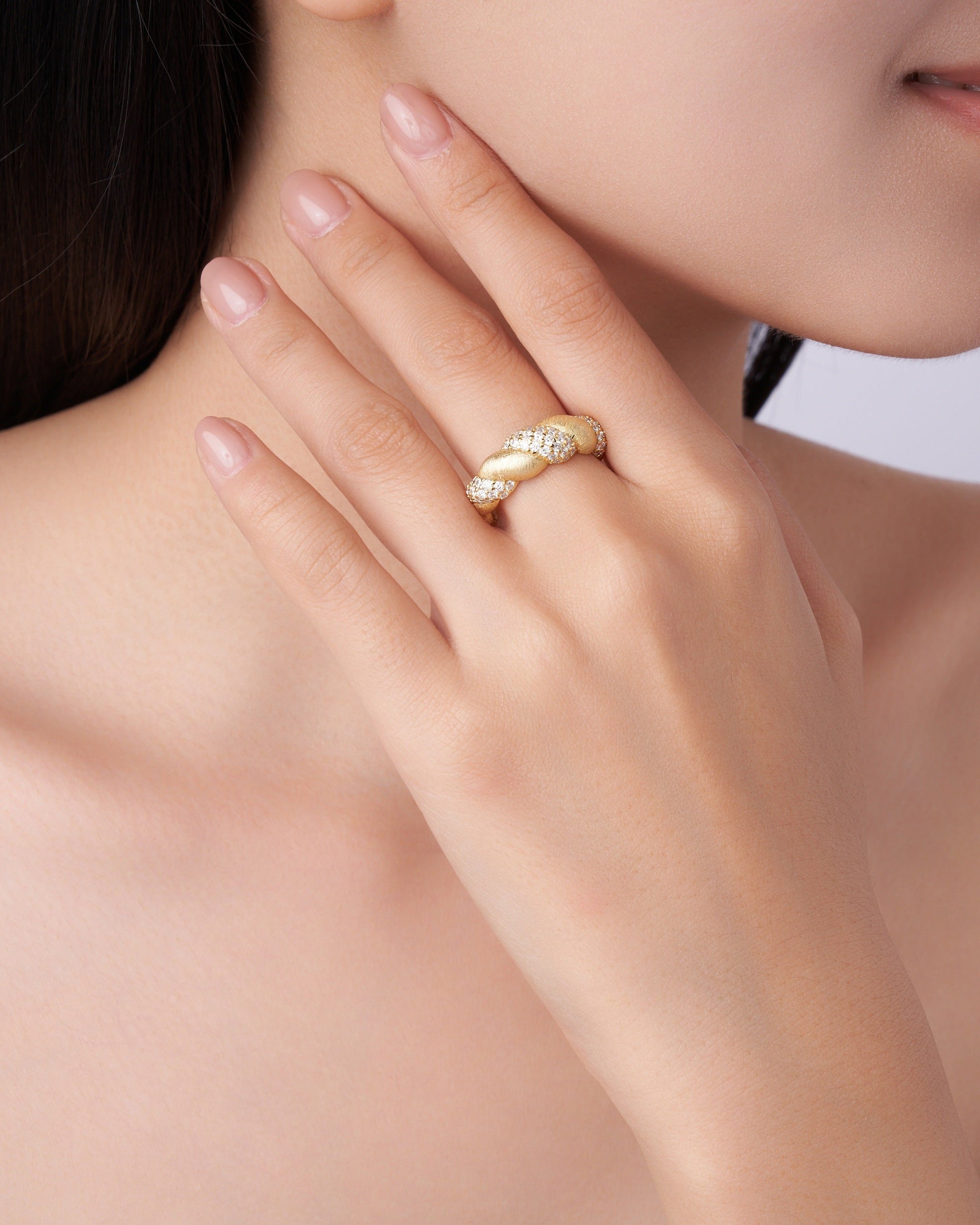 Gold ring on a hand with a neutral background