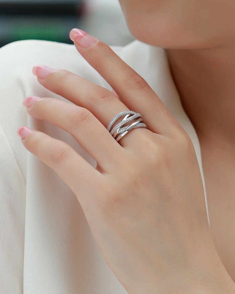 Close-up of a hand wearing a silver ring with a blurred background