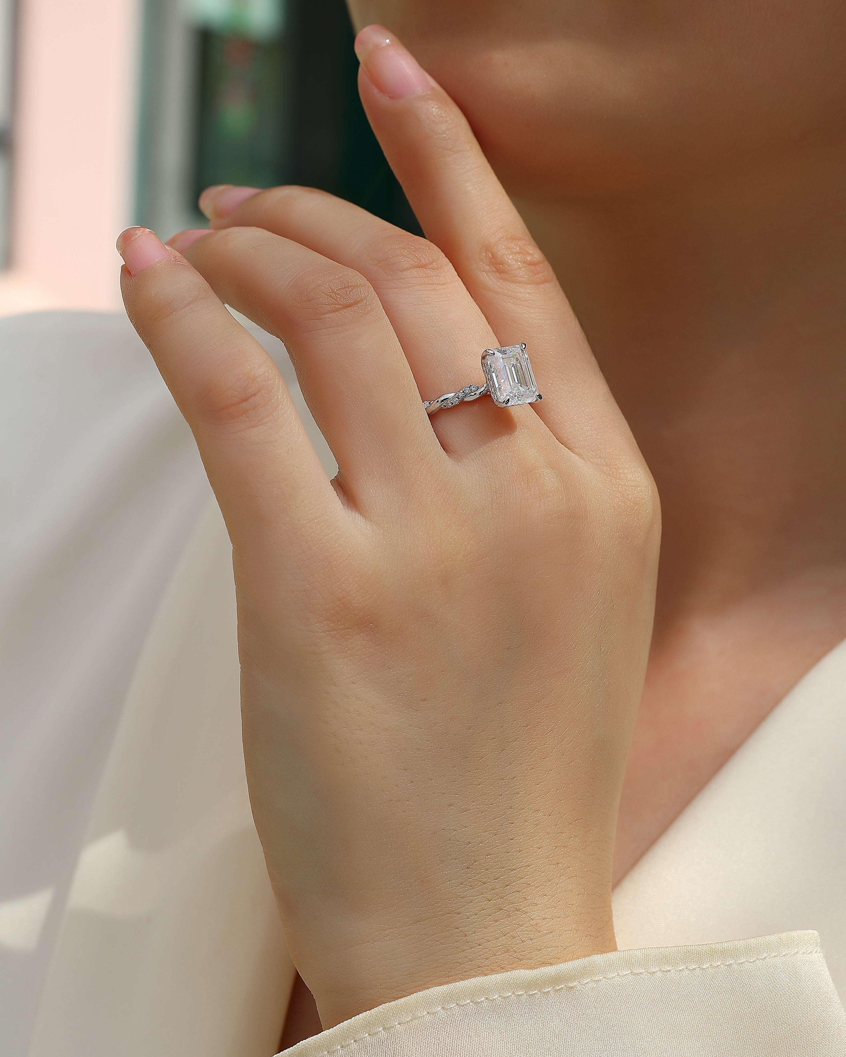 Close-up of a hand wearing a diamond ring with a blurred background