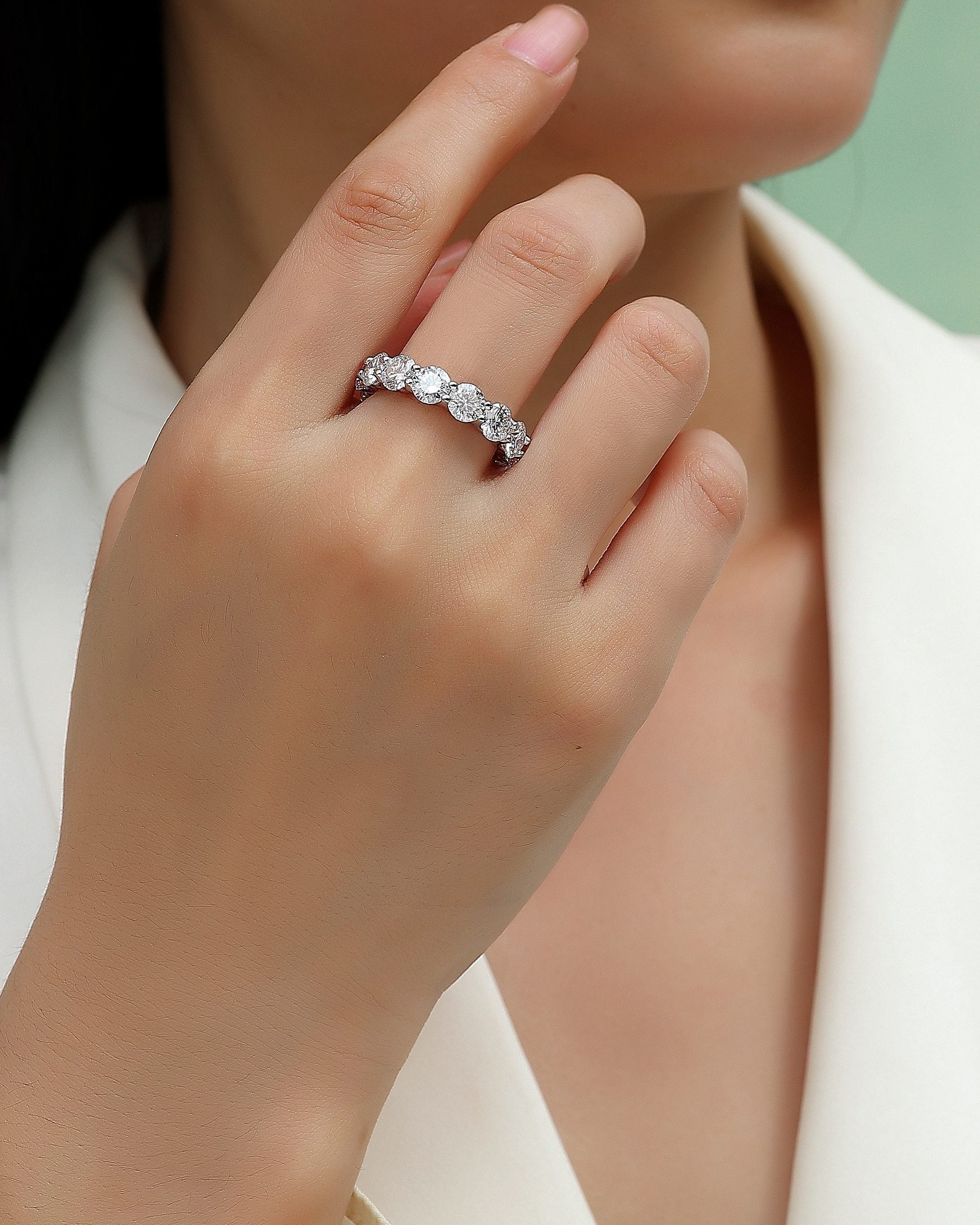 Close-up of a hand wearing a silver ring with a blurred background