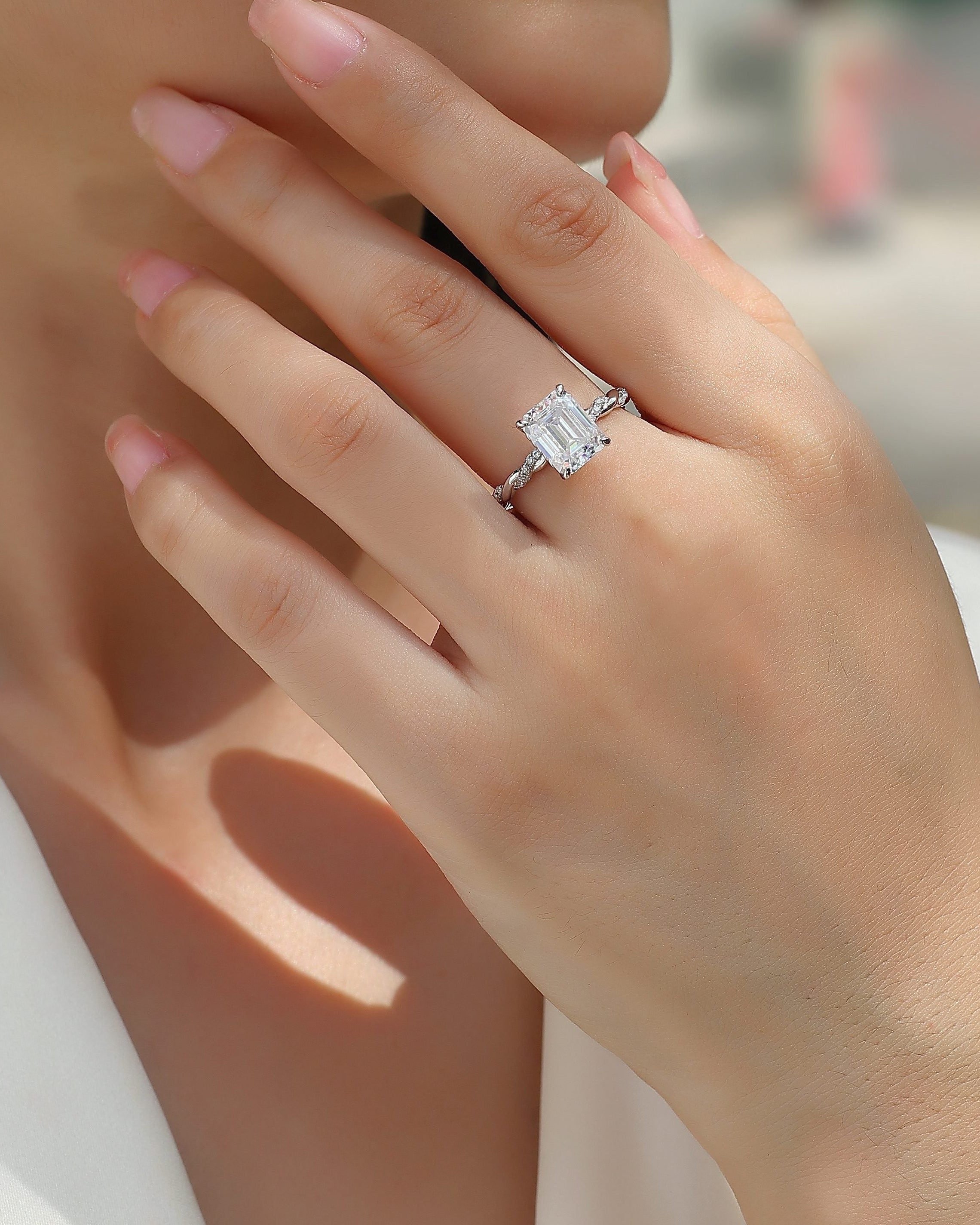 Close-up of a hand wearing a diamond ring with a blurred background