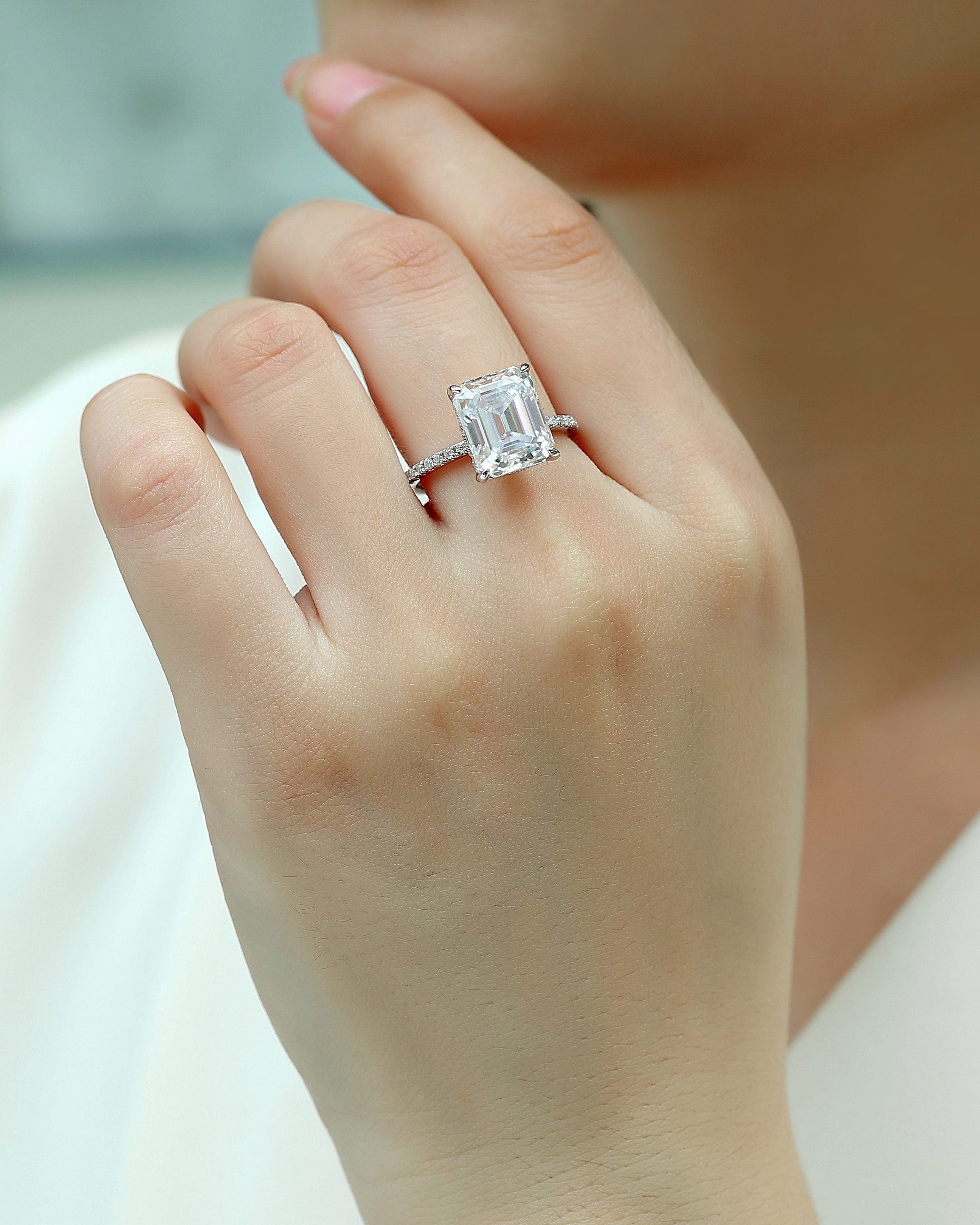 Close-up of a hand wearing a diamond ring with a blurred background