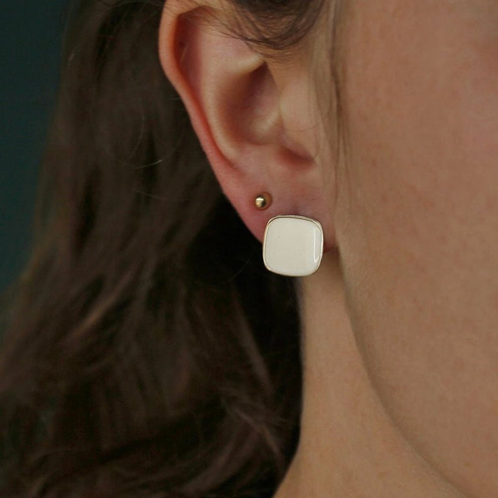 Bordeaux Enamel Earrings worn by model showcasing red enamel and gold-tone design