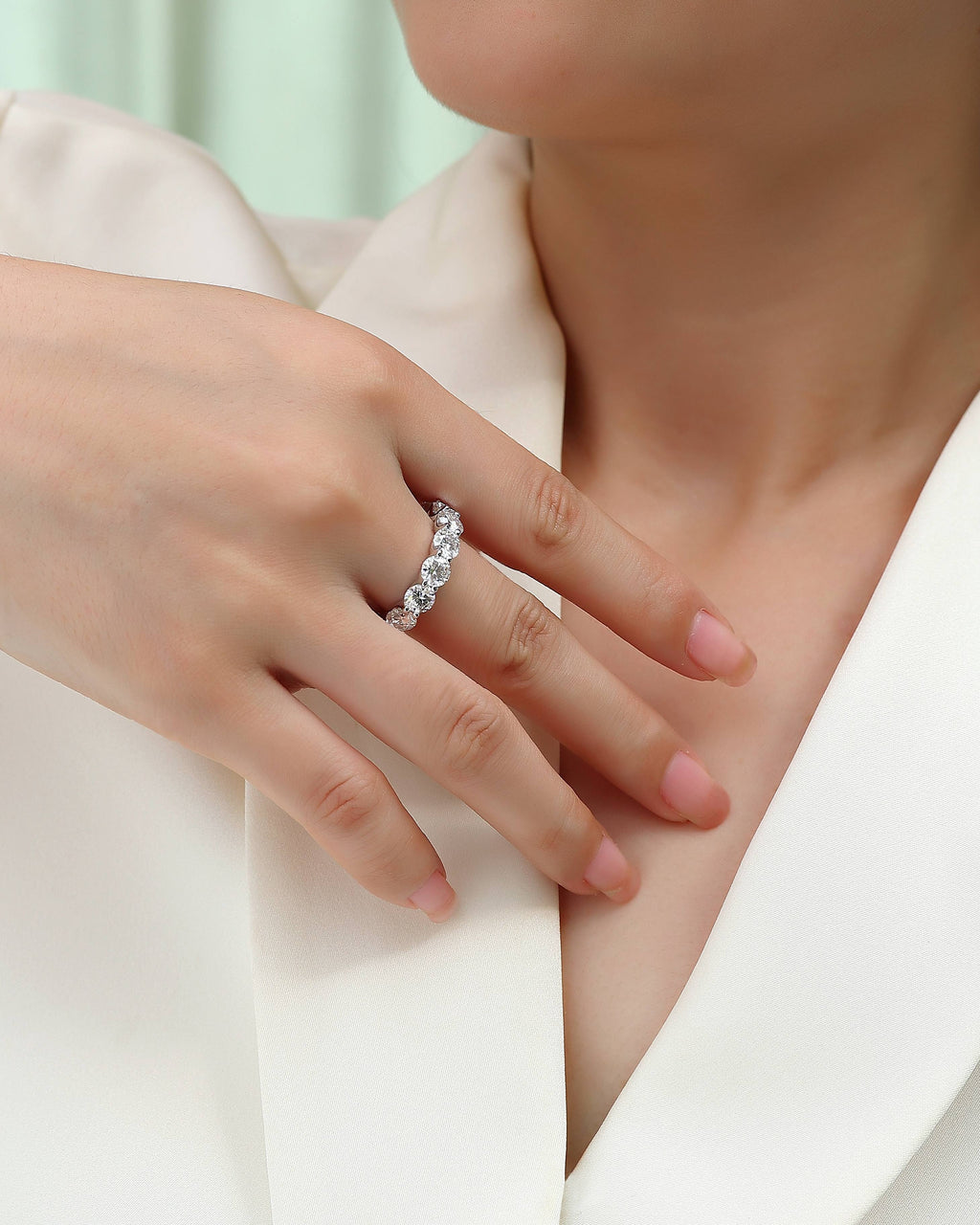 Close-up of a hand wearing a diamond ring with a blurred background