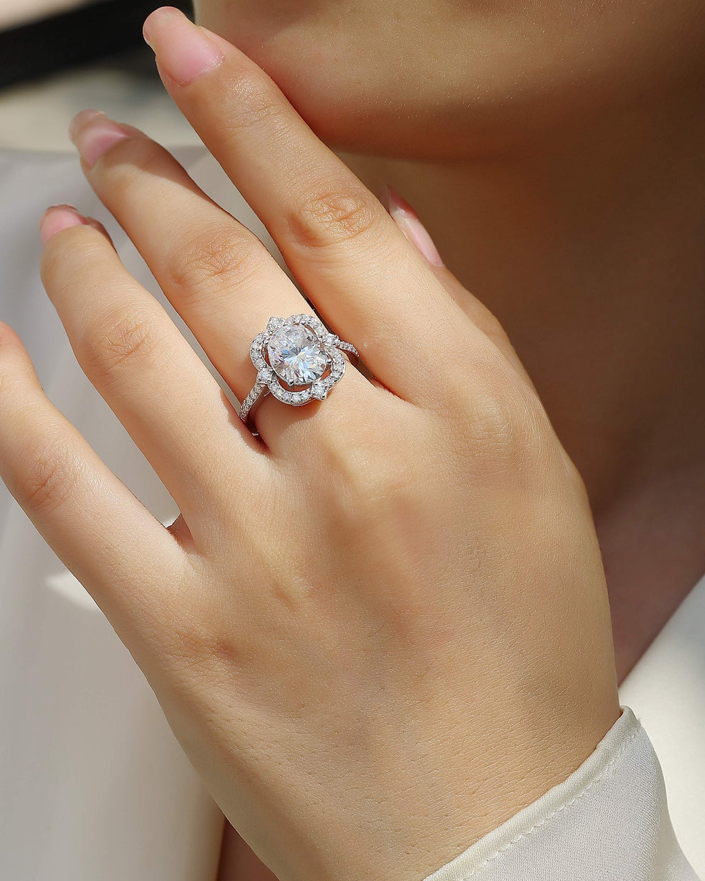 Close-up of a hand wearing a diamond ring with a blurred background