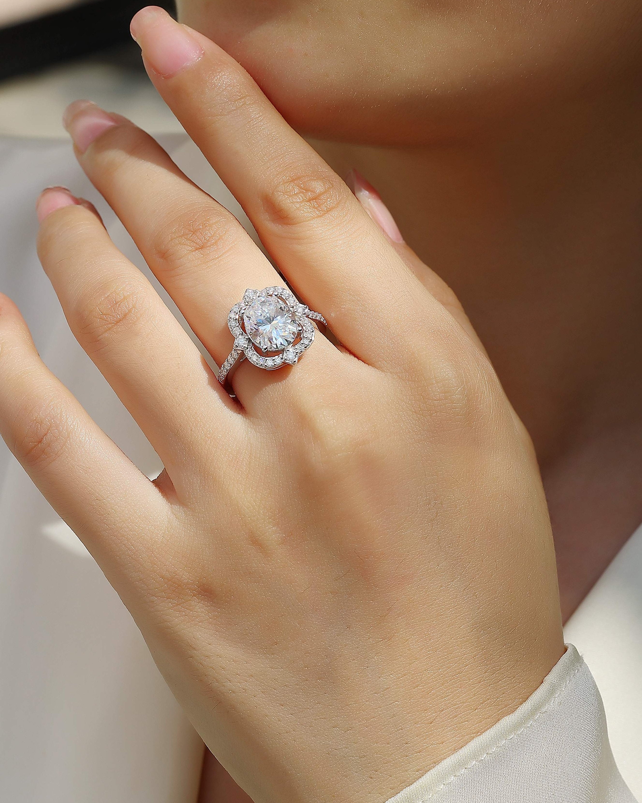 Close-up of a hand wearing a diamond ring with a blurred background
