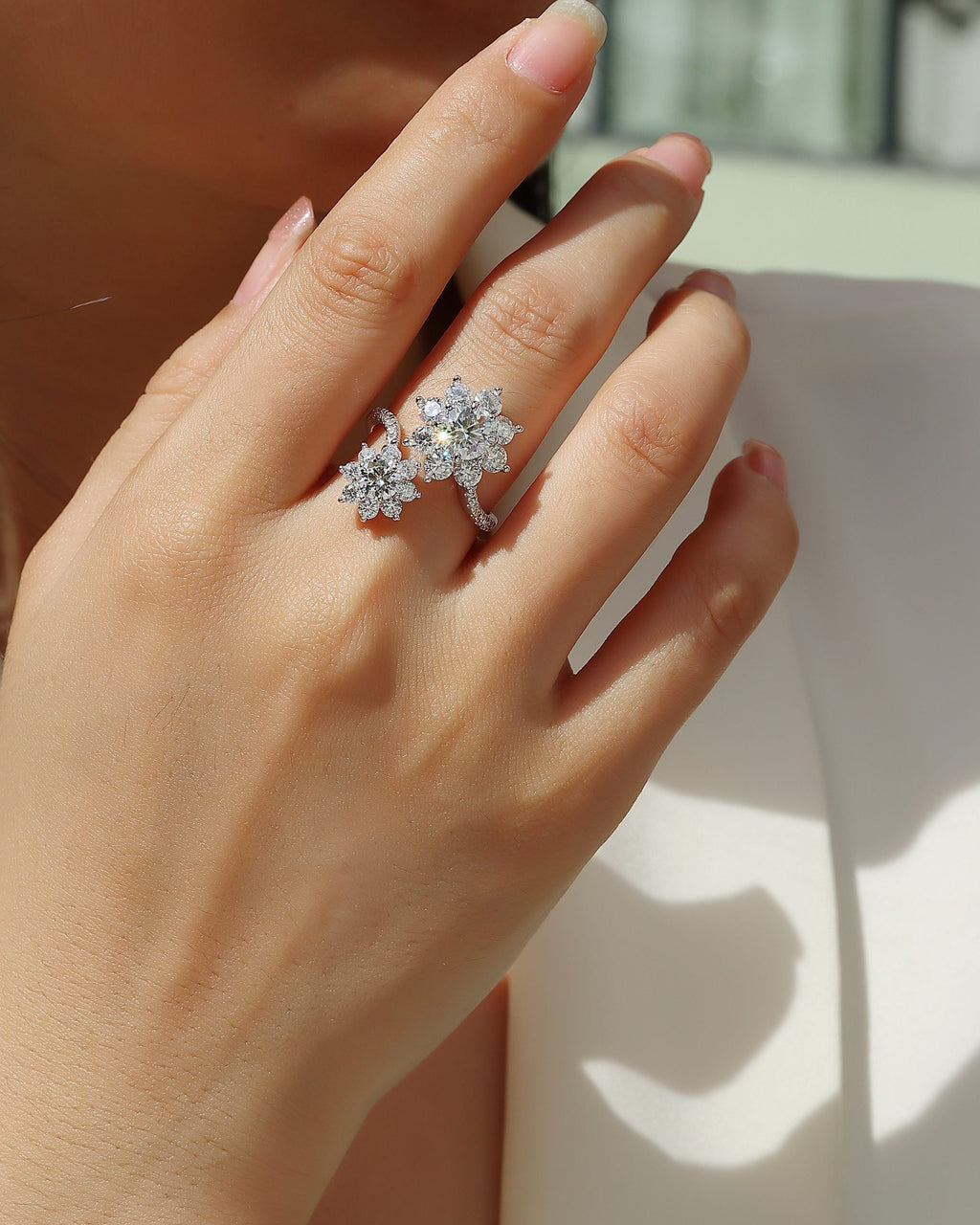 Close-up of a hand wearing a diamond ring with a blurred background