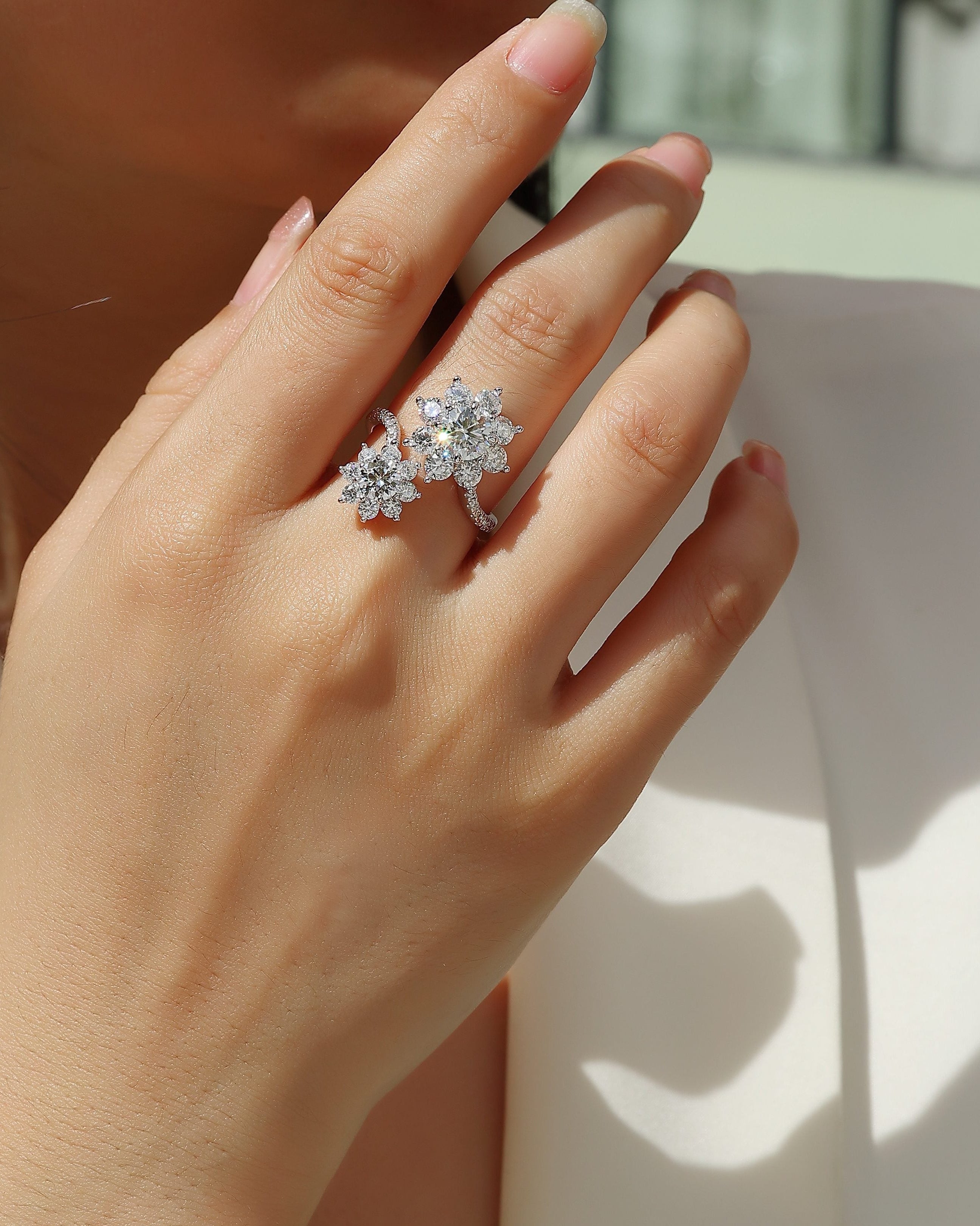 Close-up of a hand wearing a diamond ring with a blurred background