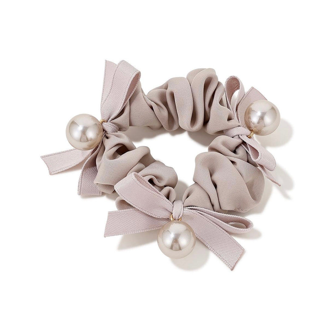 Elegant Pearl Bow Scrunchie in cream color with pearl accents on white background