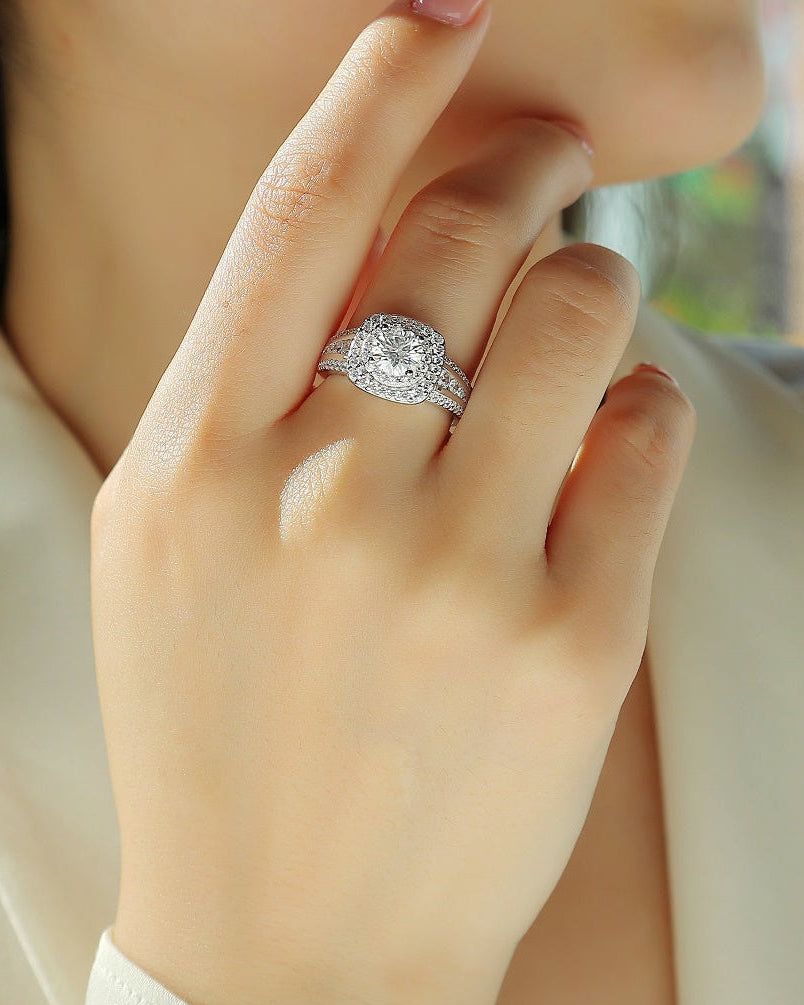Close-up of a hand wearing a diamond ring with a blurred background