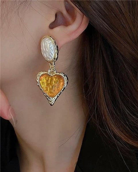 Lustrous Heart Earrings worn by model showcasing polished gold heart design and fit
