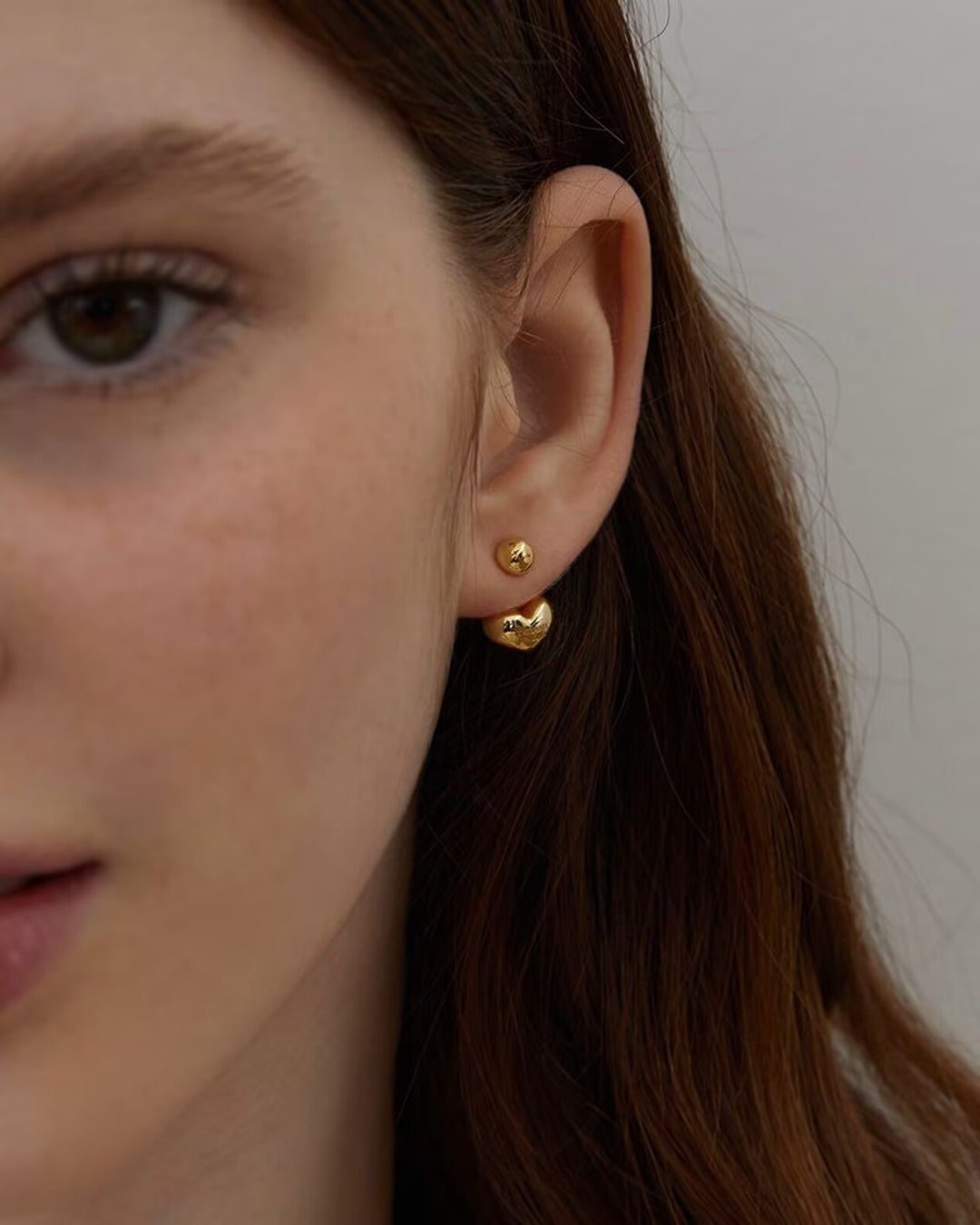 Mini Heart Earrings close-up worn by model showing gold heart detail
