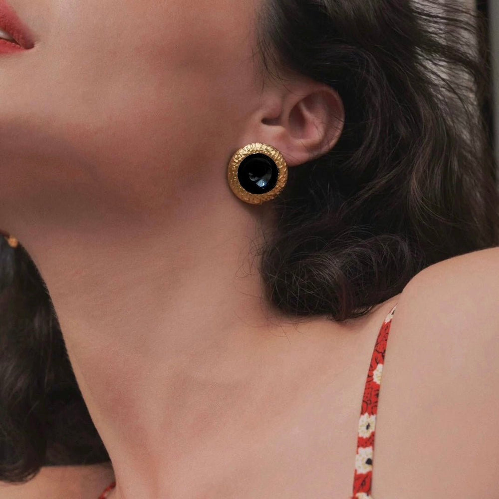Noir Crest Earrings worn by model showing black enamel and gold crest design