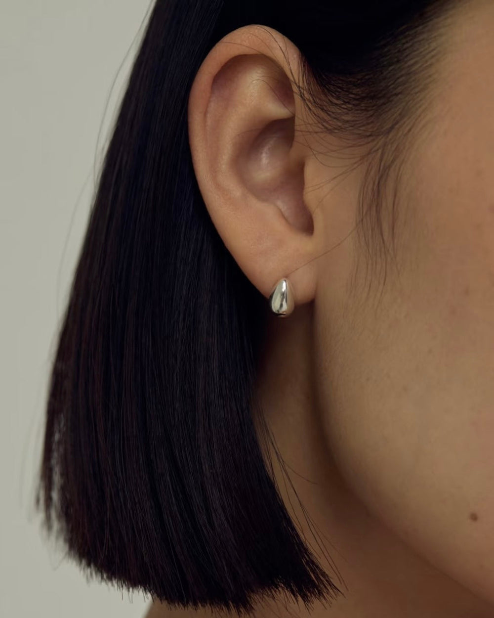 Teardrop Earrings close-up worn by model showcasing gold teardrop detail
