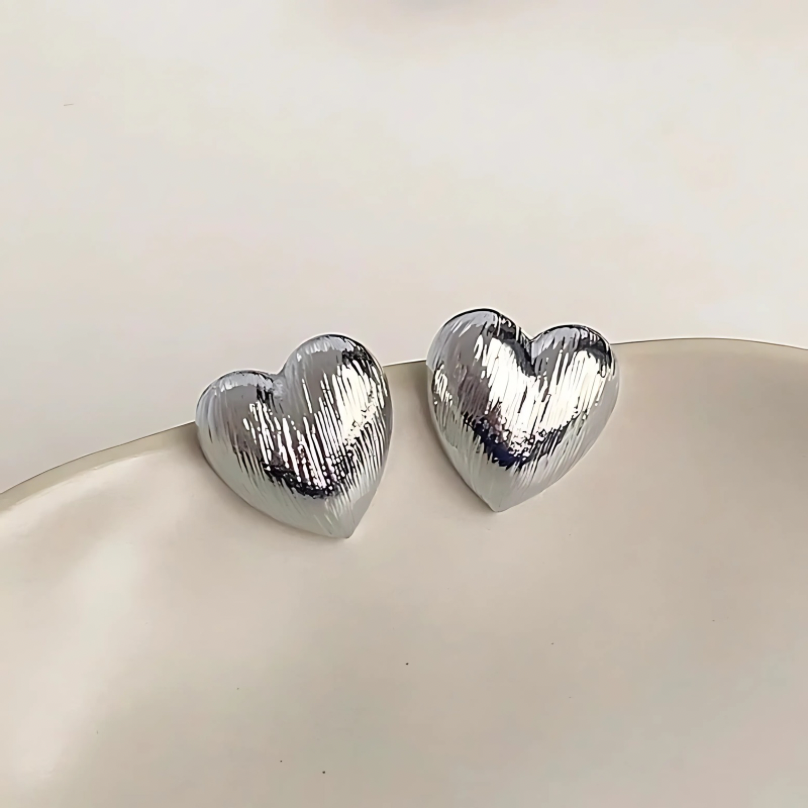 Close-up detail of Textured Heart Earrings showing textured gold finish
