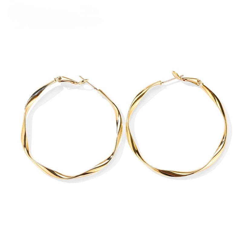 Twist Shine Hoop Earrings shown from side angle highlighting twisted gold shape on white background
